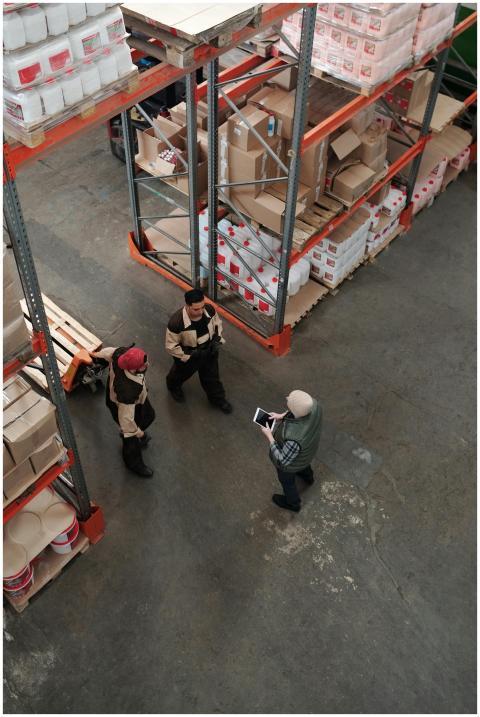 Workers discuss logistics in a busy warehouse sett