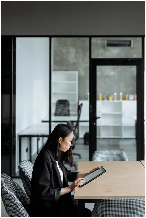 Asian woman focused on using a tablet in a modern