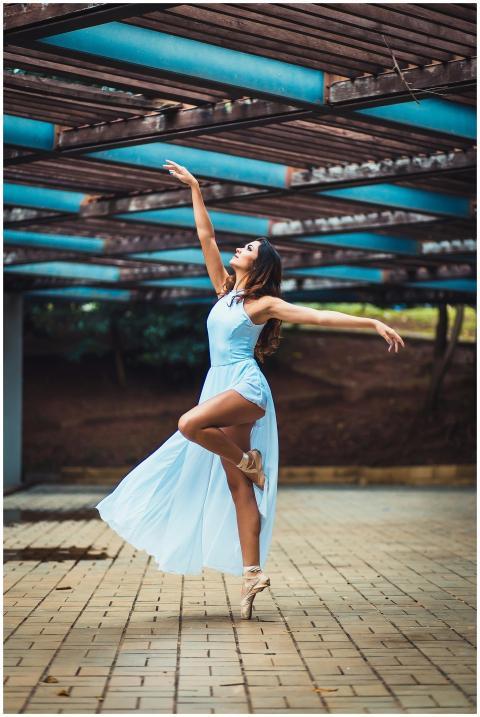 Graceful ballerina dances outdoors in a flowing bl