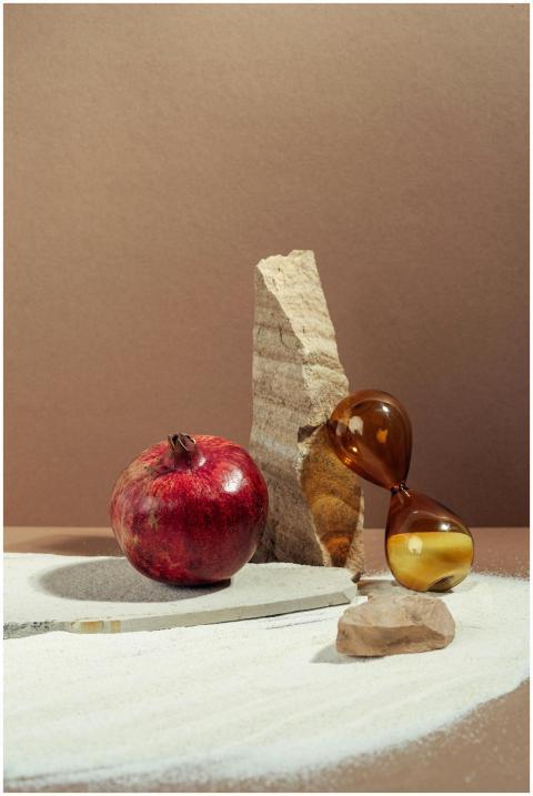 Elegant still life of a pomegranate beside an ambe