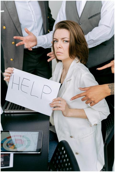 Businesswoman overwhelmed by colleagues, holding a