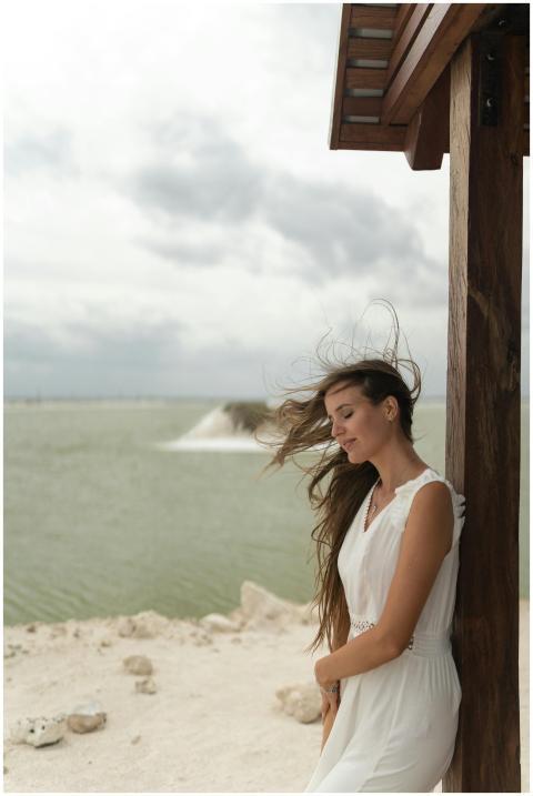 Woman in white dress by a lagoon in Mexico, calm a