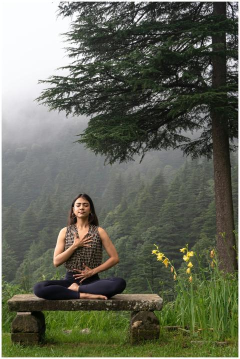 Woman practicing meditation in serene forest envir