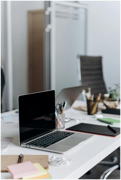 A neat office desk setup with an open laptop, stat