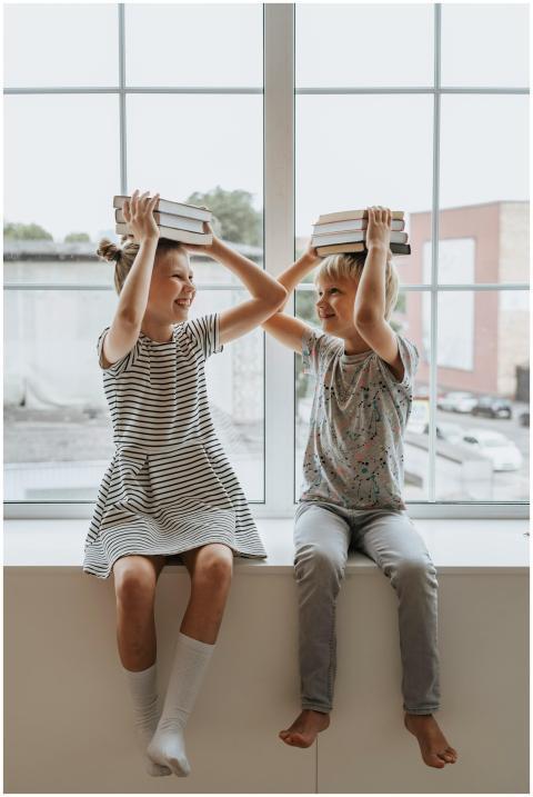 Two happy children playing with books, embodying t