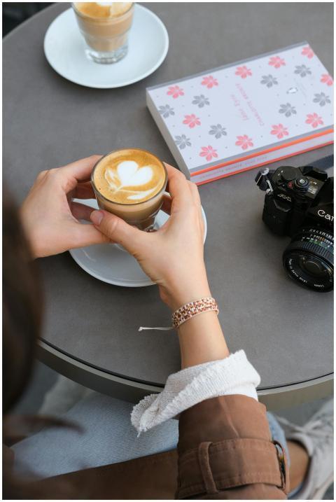 Cappuccino with latte art next to a camera in a co