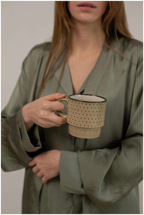 A woman in green sleepwear holding a decorative ce