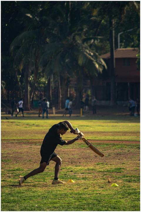 A young man actively playing cricket on a sunny da