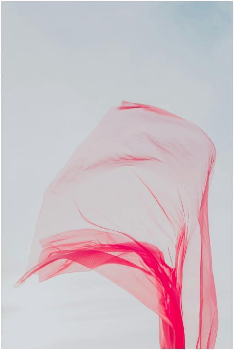 Graceful sheer red fabric flowing in the wind agai