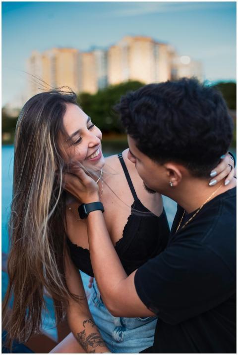 Happy young couple embracing by the water with cit