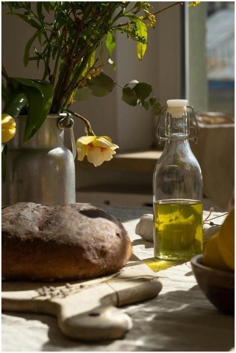 A serene kitchen setup featuring fresh bread, oliv