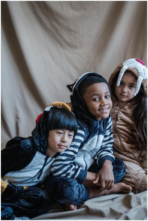 Adorable children in animal costumes sitting toget