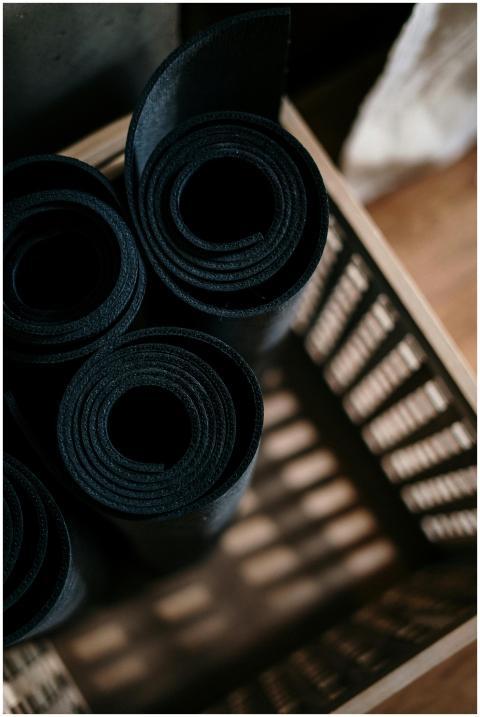 Close-up of rolled yoga mats in a basket at a fitn