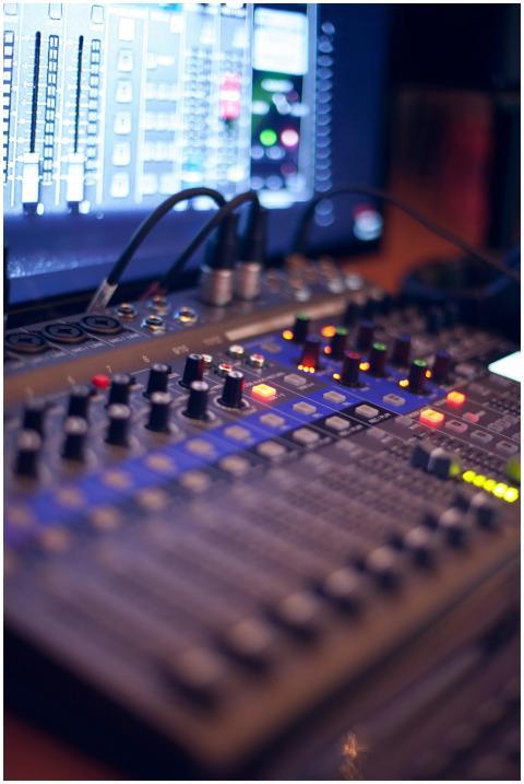 Close-up of a professional audio mixing console wi