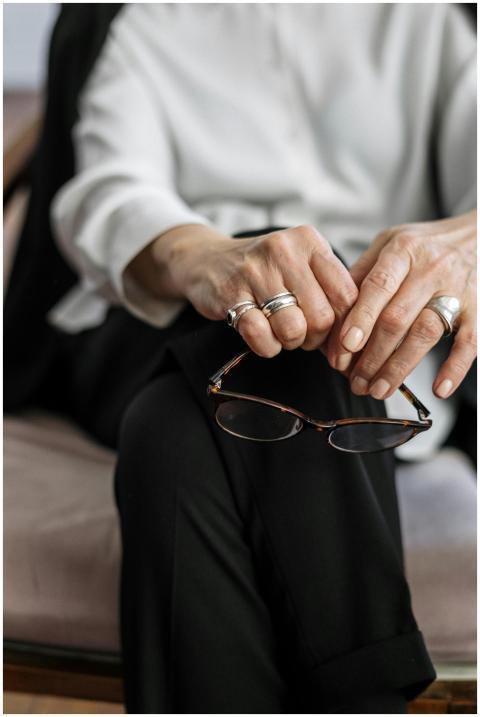 A close-up of a therapist's hands with glasses, sy