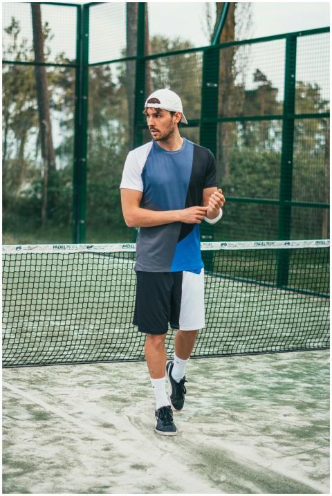 Athletic man in sportswear standing on a tennis co