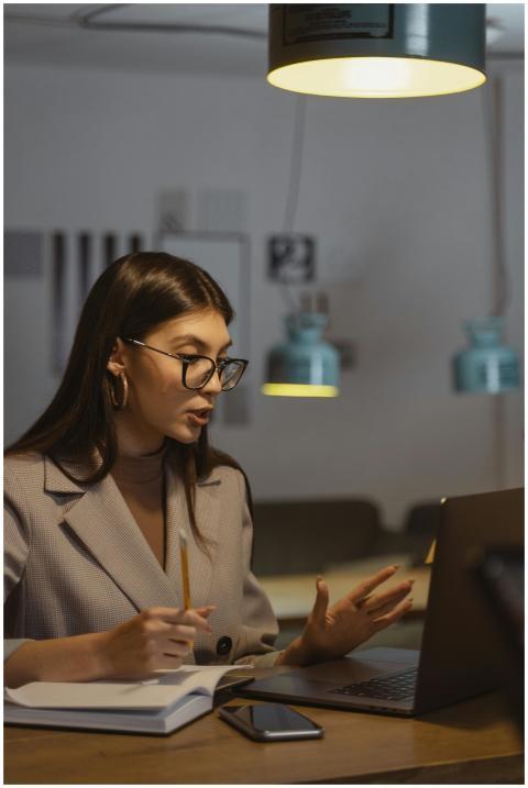 A young businesswoman working late at her desk, en