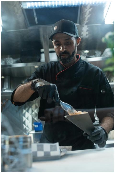 Chef in a food truck kitchen preparing a dish with