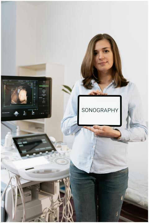 A pregnant woman holding a sonography sign standin