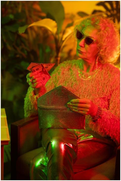 Elegant senior woman in fashionable outfit, holdin