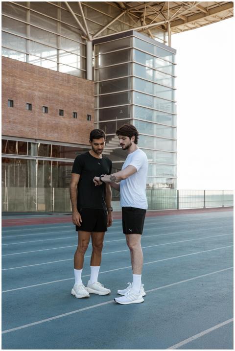 Two male athletes in sportswear discussing a worko