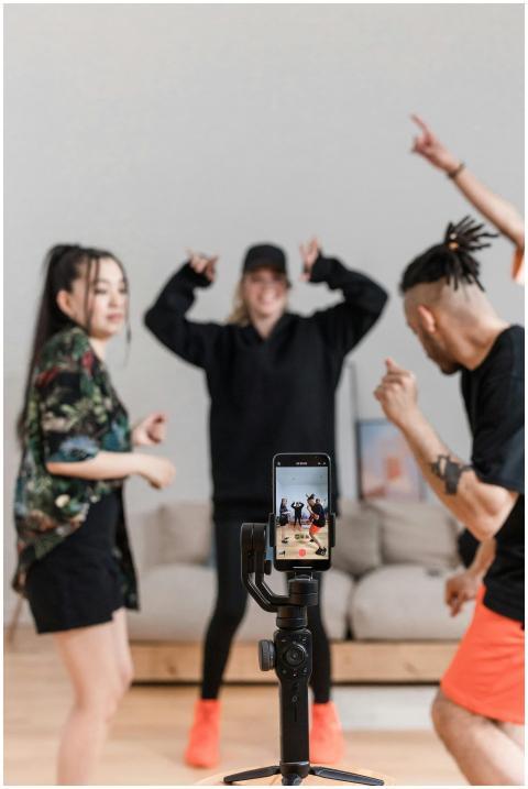 Energetic group of friends dancing and recording a