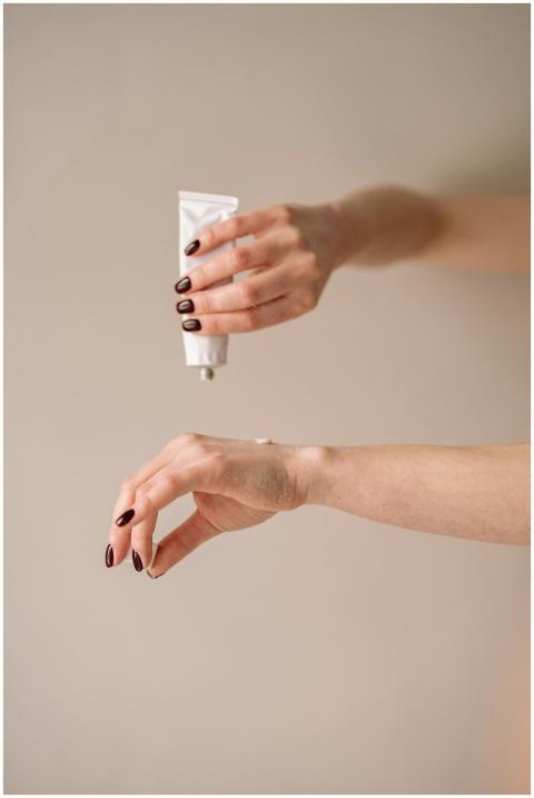 Close-up of a woman applying moisturizer to her ha