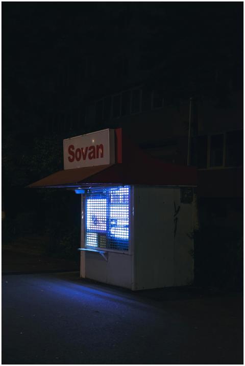 A brightly lit small food stand named Sovan in Clu