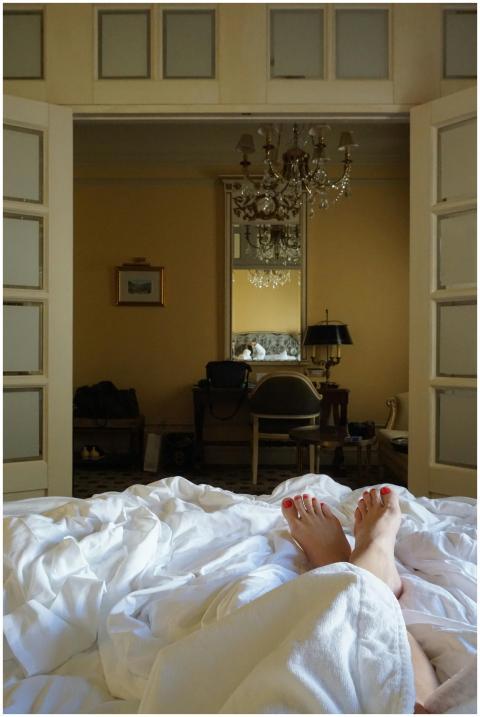 Elegant bedroom with chandelier viewed from bed, o
