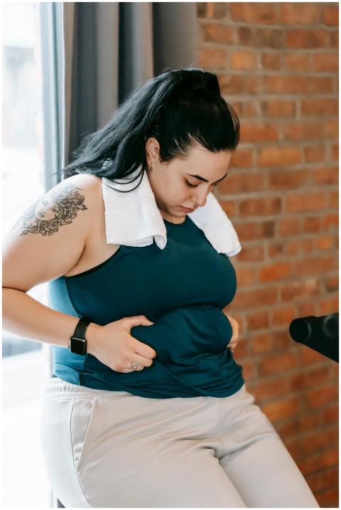 Upset young obese female in sportswear leaning on