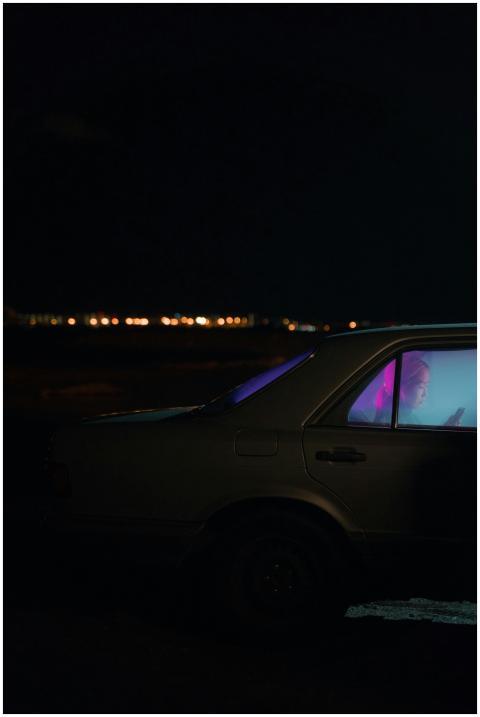 A woman sitting in a car using her smartphone, ill