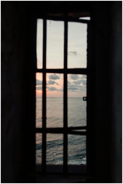 Dramatic ocean view with a sunset framed through w