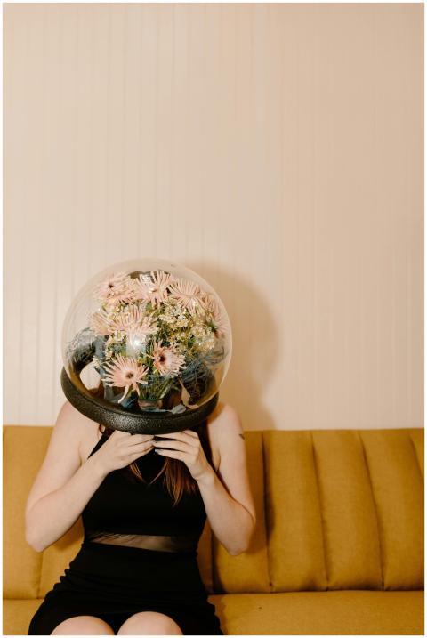 A woman in a black dress wears a flower-filled dom