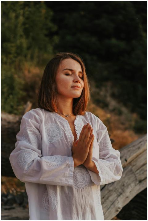 Peaceful woman with closed eyes meditating in natu