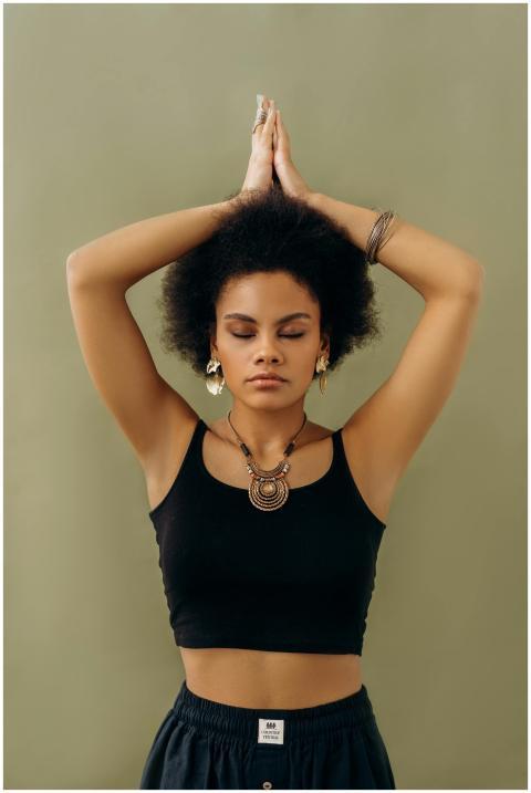 A woman in a yoga pose with closed eyes, symbolizi