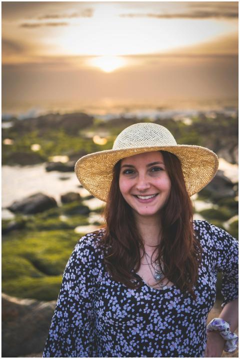 Smiling woman in a straw hat enjoys a beautiful su