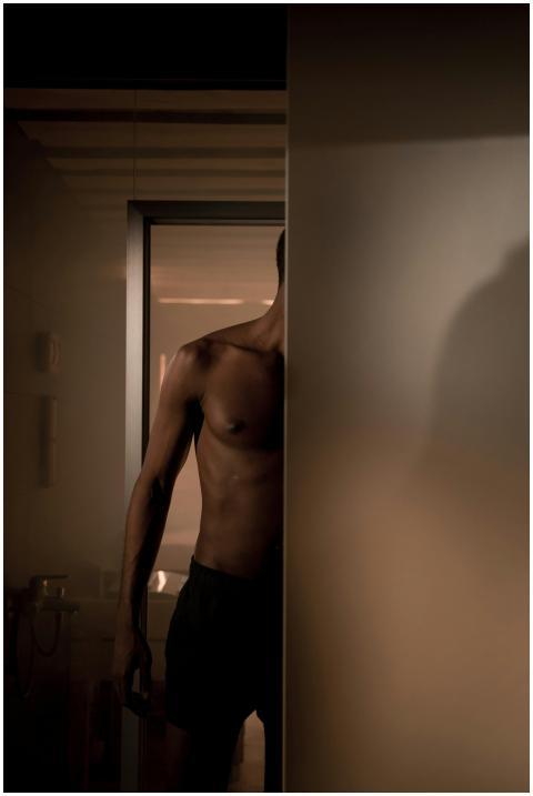 A muscular, shirtless man partially hidden in a di