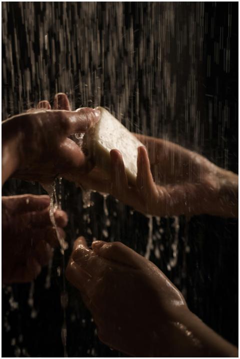 Artistic shot focusing on hands under streaming wa