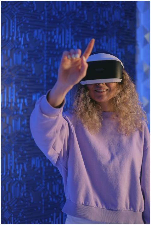A woman wearing a VR headset interacts with a virt