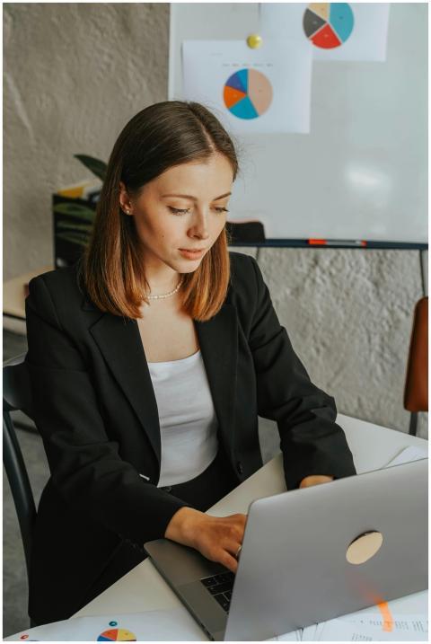 Confident businesswoman working on a laptop in a m