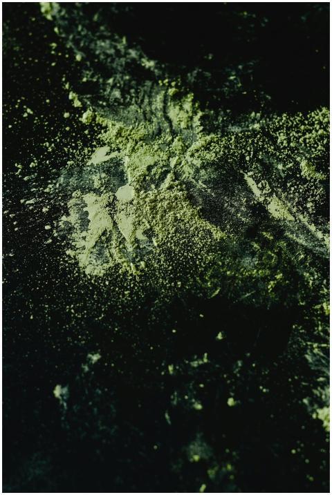 Close-up of organic matcha powder scattered on a d