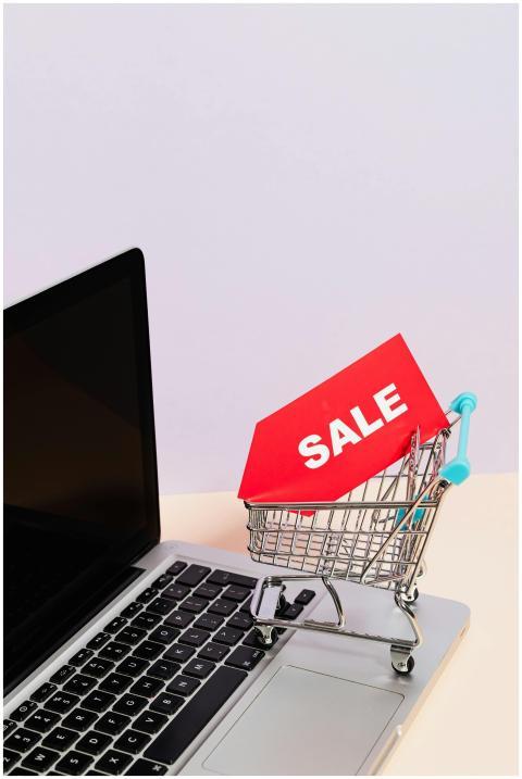 Mini shopping cart with sale tag on laptop for onl