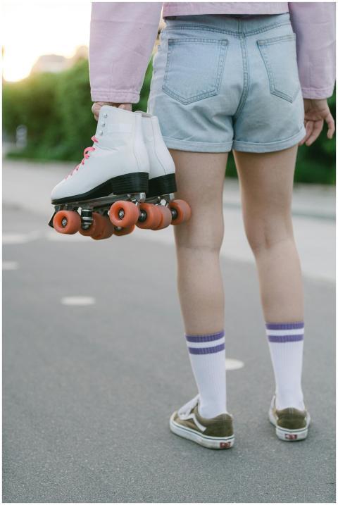 A person in denim shorts and pink jacket holding r