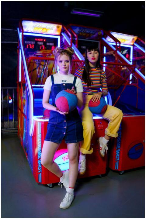 Two young women playing basketball arcade games wi