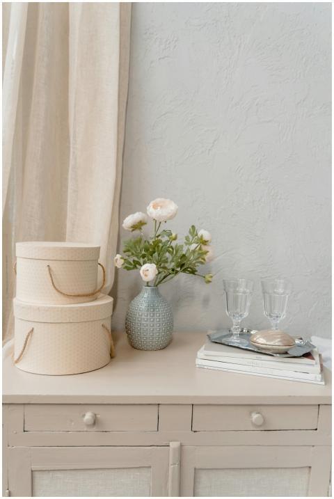 A minimalist still life featuring flowers in a vas