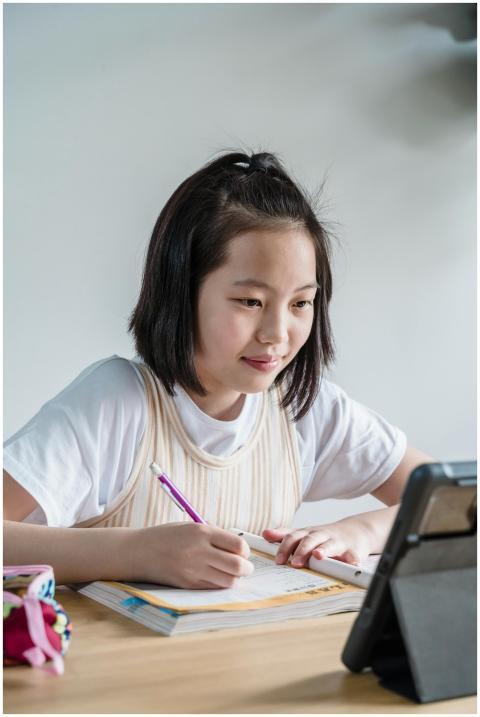 A girl using a tablet for remote learning, focused