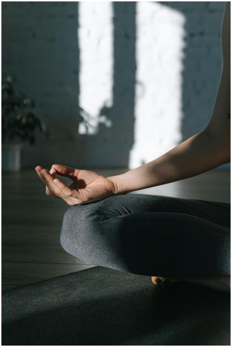 A person meditating in a tranquil yoga pose indoor