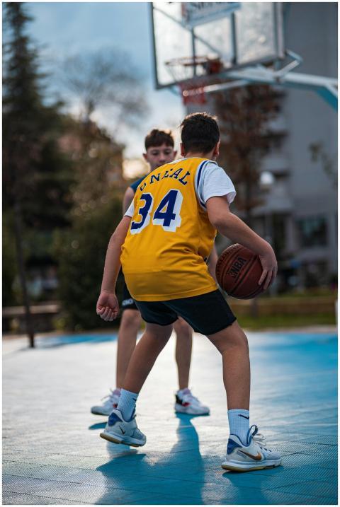 Two boys enjoy a basketball game on an outdoor cou