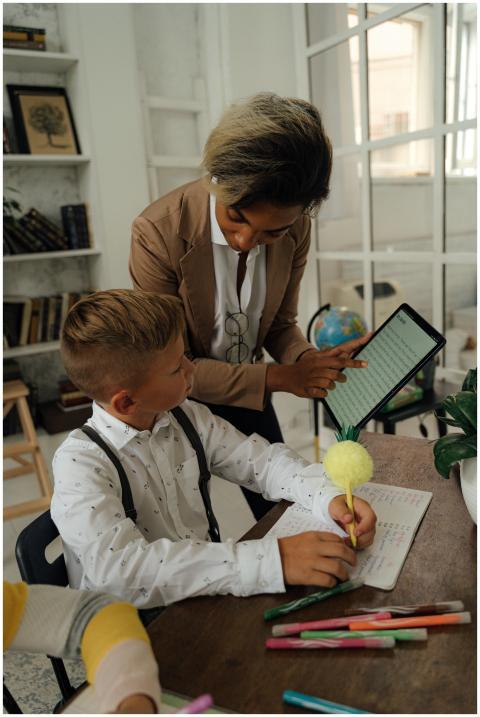 Teacher helping a student with tablet during class