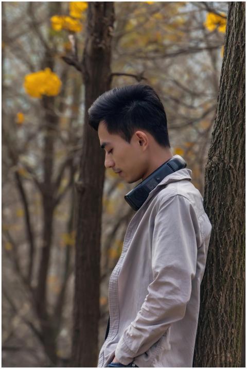 Side view of a young man with headphones, leaning